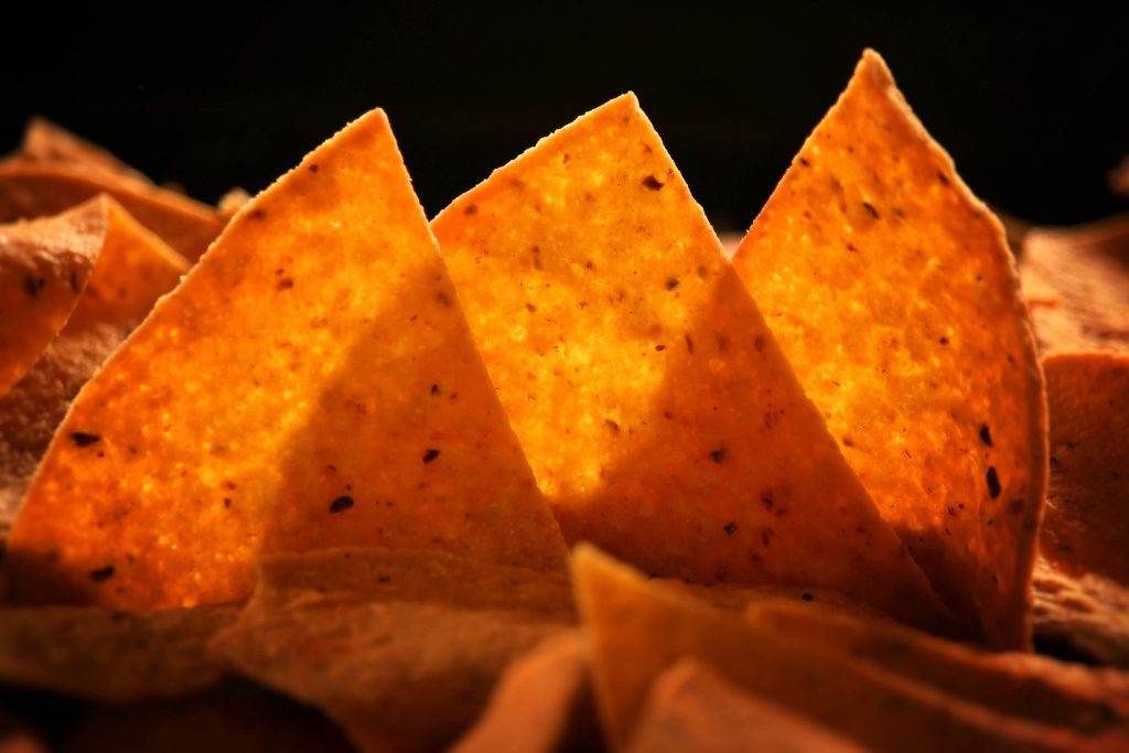 Delicious crispy corn chips perfectly lit, showcasing their golden texture and inviting appeal.